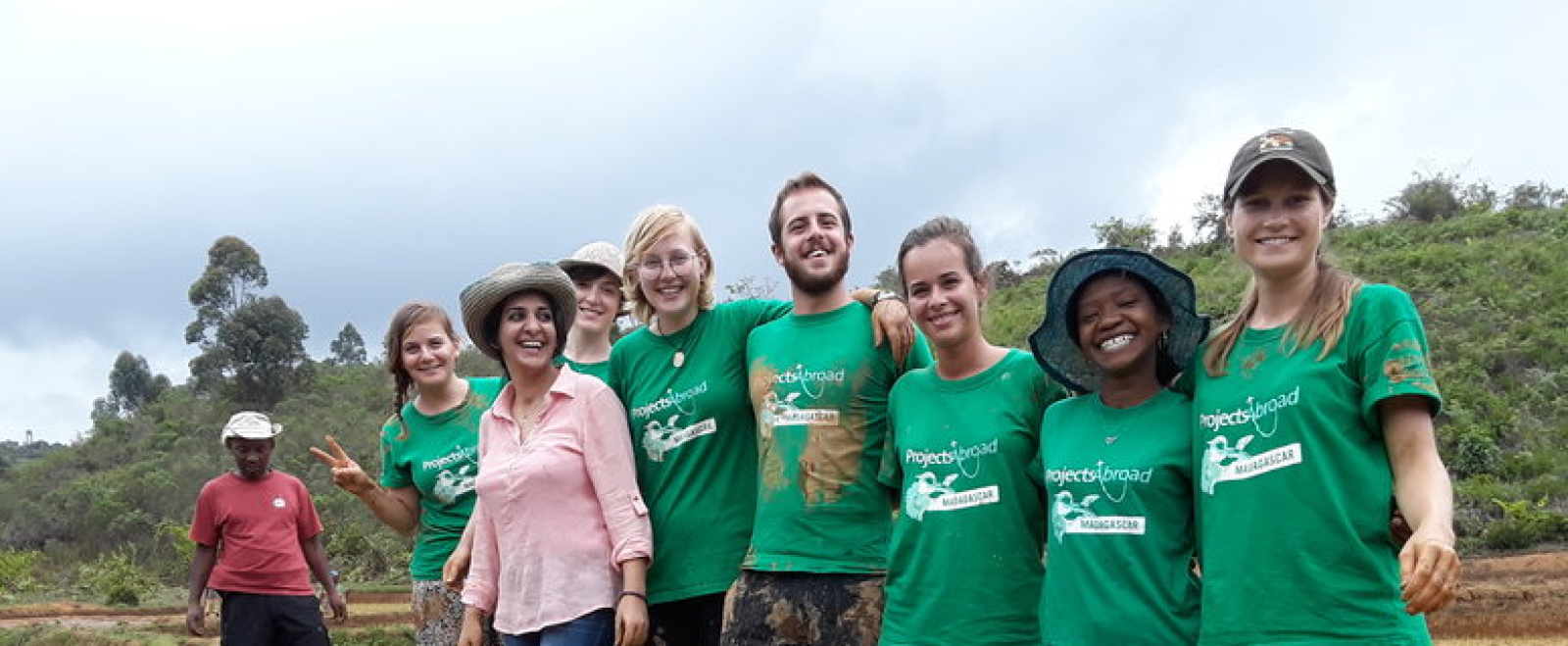 A group of volunteers work together to plant rice with local farmers in Madagascar, Africa. 