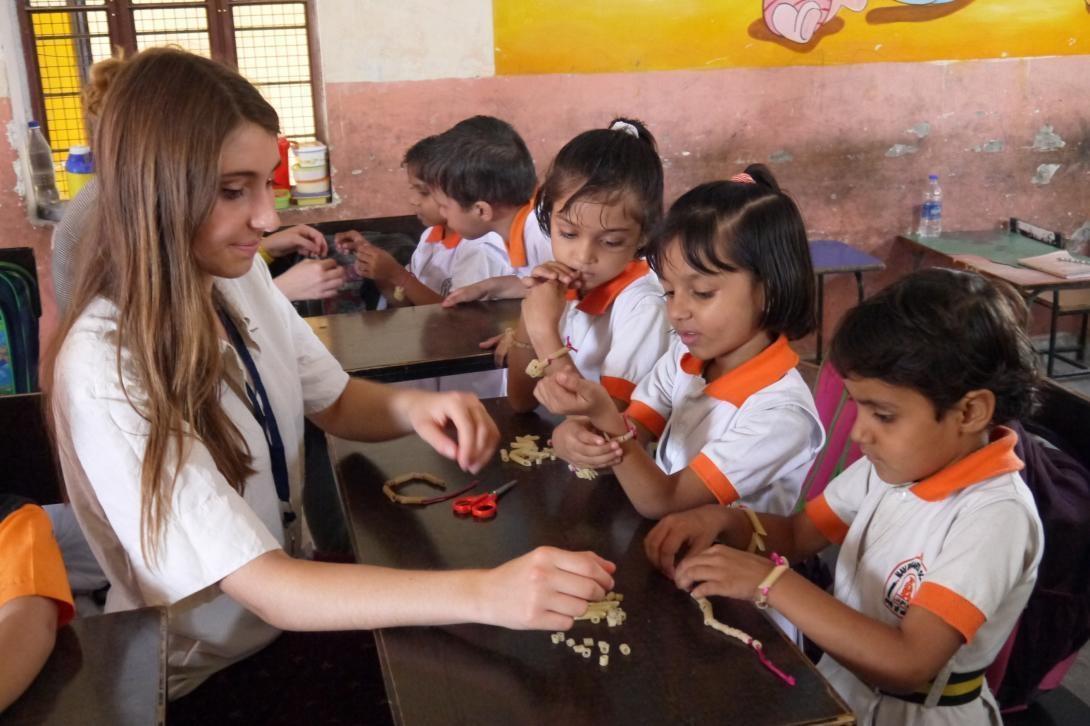 Childcare volunteer in India does arts and crafts with children in a Jaipur elementary school