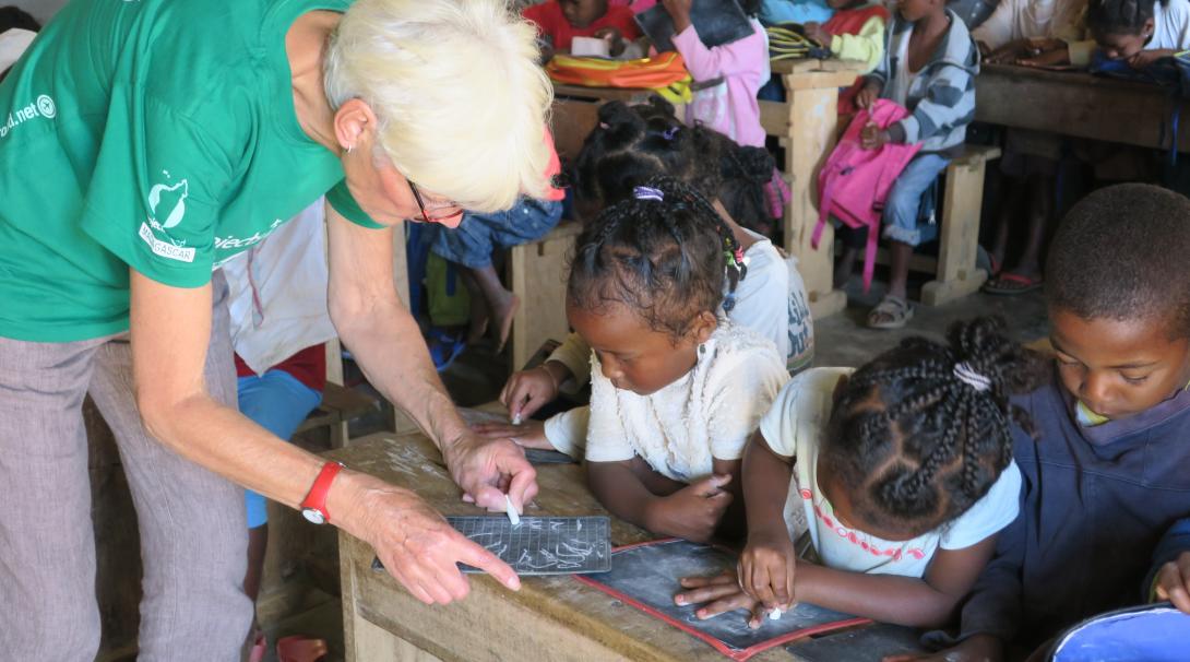 On a volunteer abroad program for older adults, a woman works with school children in Madagascar.
