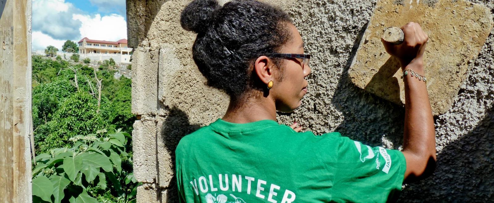 A Projects Abroad volunteer helps with plastering a wall during her volunteer building work abroad.