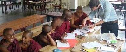 A volunteer helps his students with their classwork during his teaching work experience in Sri Lanka