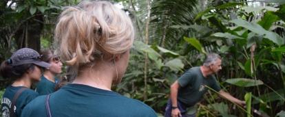 A staff member shows teenagers different species during rainforest conservation volunteering in Peru