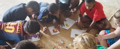 A volunteer and her students play with finger paints during her volunteer work with children for teenagers in Fiji