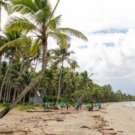 Volunteers in the South Pacific work together to clear rubbish off a beach in Fiji. 