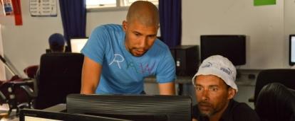 Volunteer helping a students with his assignment during IT teaching experience in South Africa