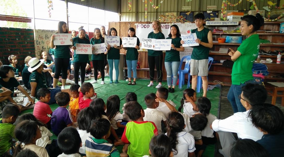 Children listen to a public health lesson on healthy living.