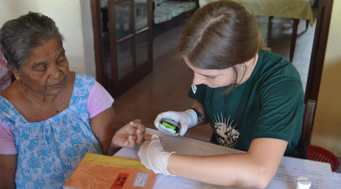 A short term nursing volunteer abroad assists during an outreach. 