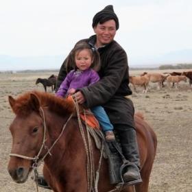 A father and daughter ride a horse at our Nomad Project for volunteers in Mongolia. 