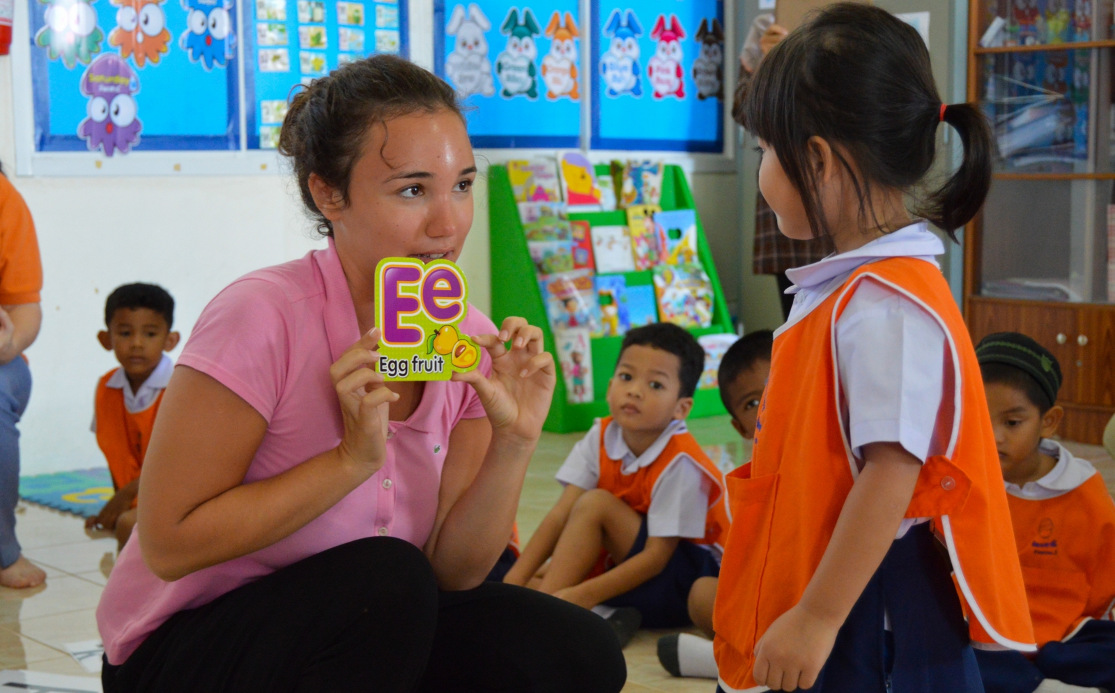 A gap year volunteer abroad teaches a child the alphabet in Thailand as part of her Childcare Project.
