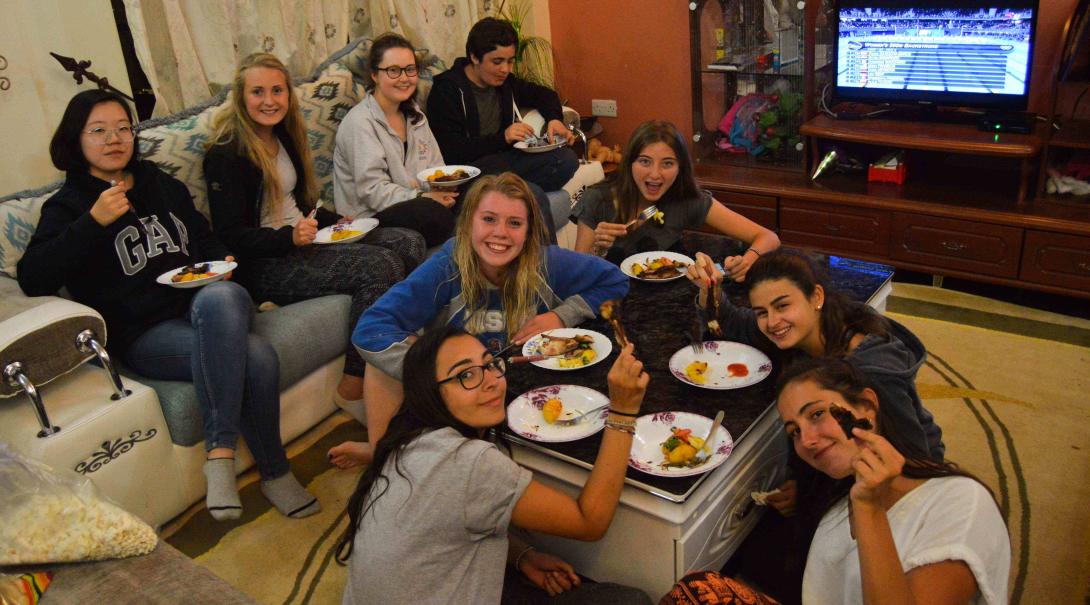  Projects Abroad volunteers enjoy dinner in their host family’s living room in Kenya