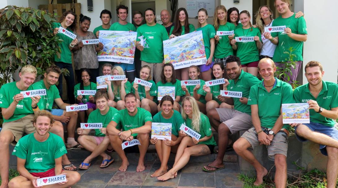 Projects Abroad volunteers take a group photo with their “I love sharks” sign