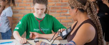 A Projects Abroad volunteer at her Spring Break Public Health placement checking the blood pressure of a local woman