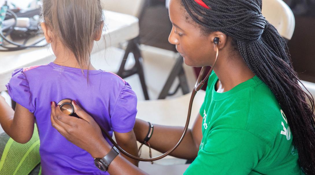 On a volunteering abroad project for college students in Mexico, a child's heart rate is checked. 