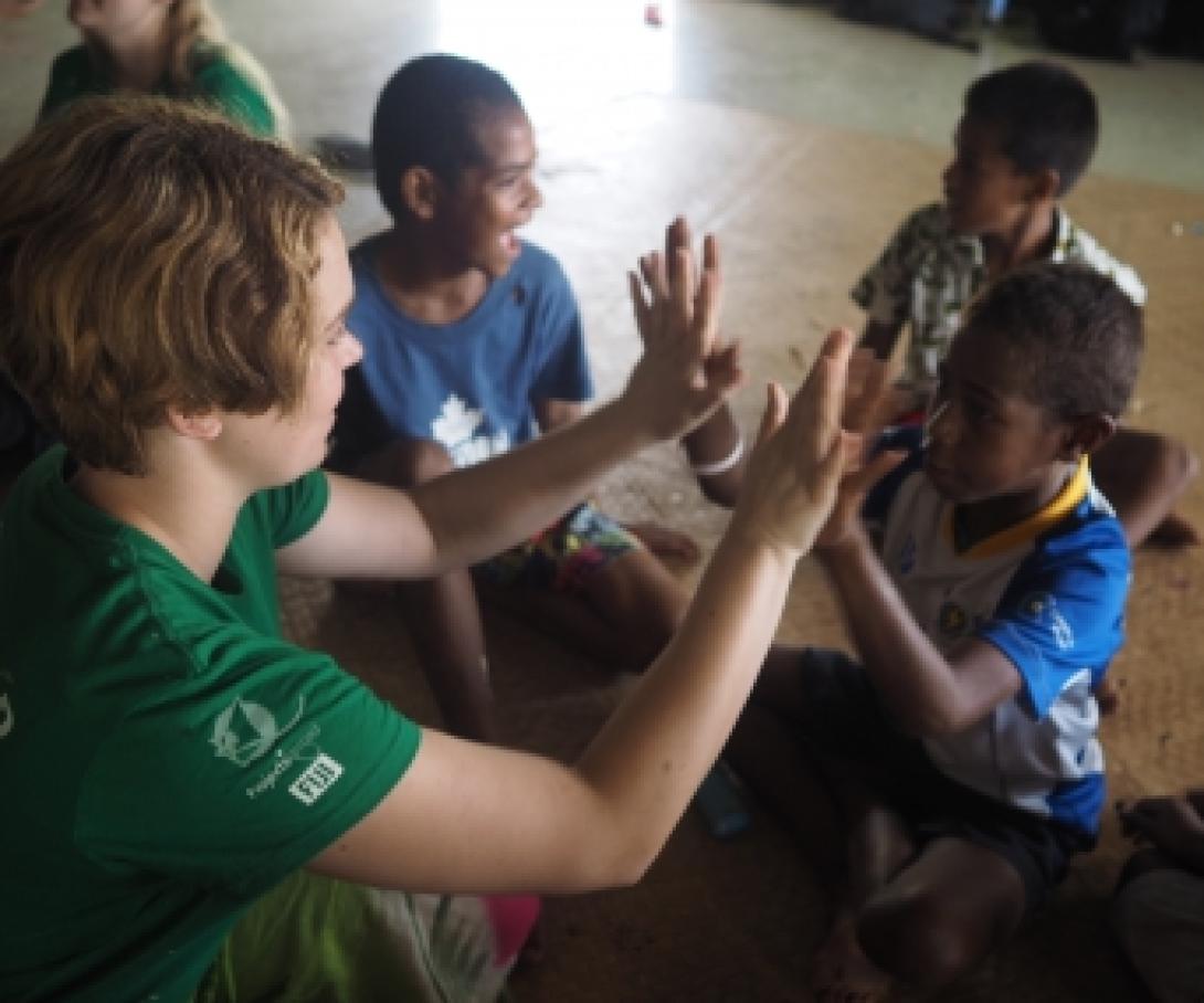 A volunteer in the South Pacific works with children and plays a game at a care center.