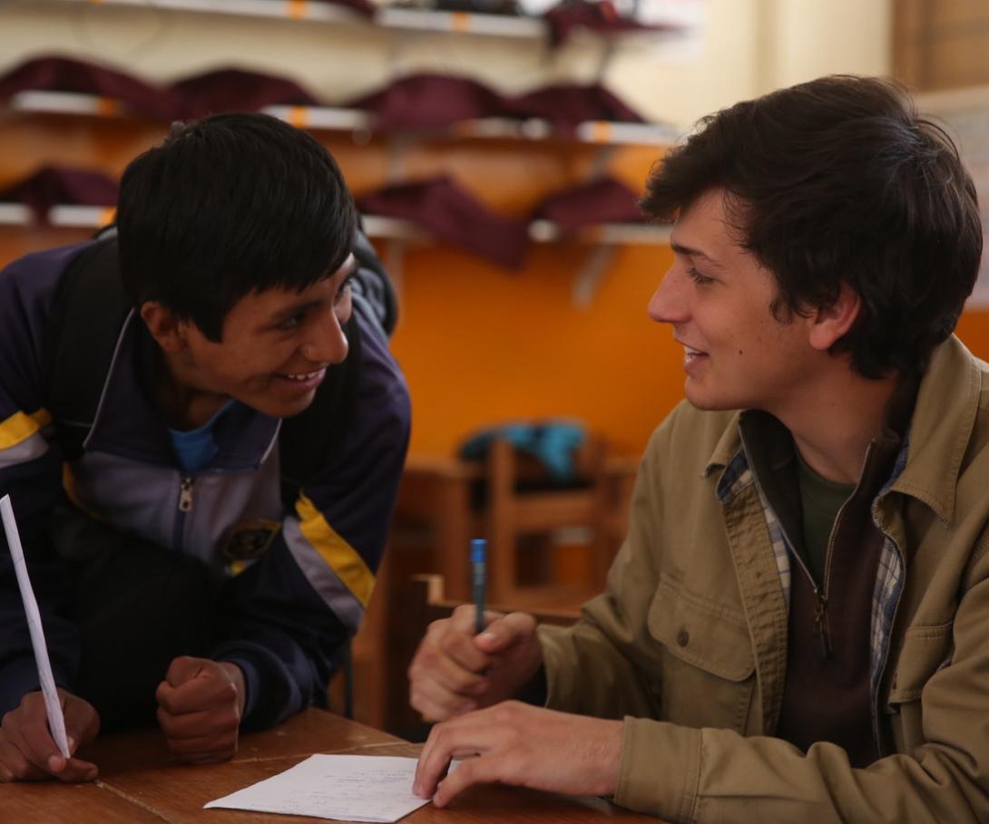 A volunteer teaching English in Peru chats to a student between classes. 
