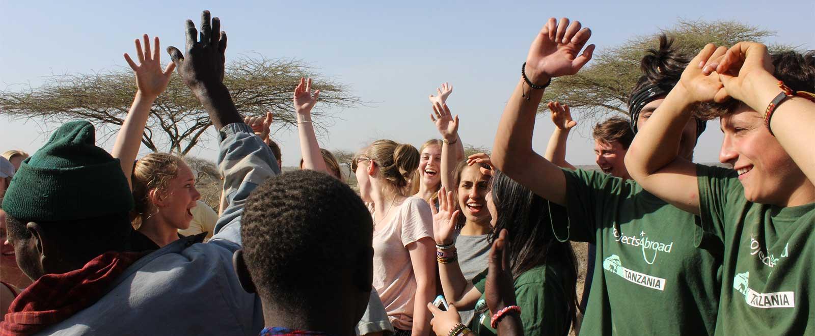 A group of volunteers abroad spend an afternoon learning about Masaai culture in Tanzania, Africa. 